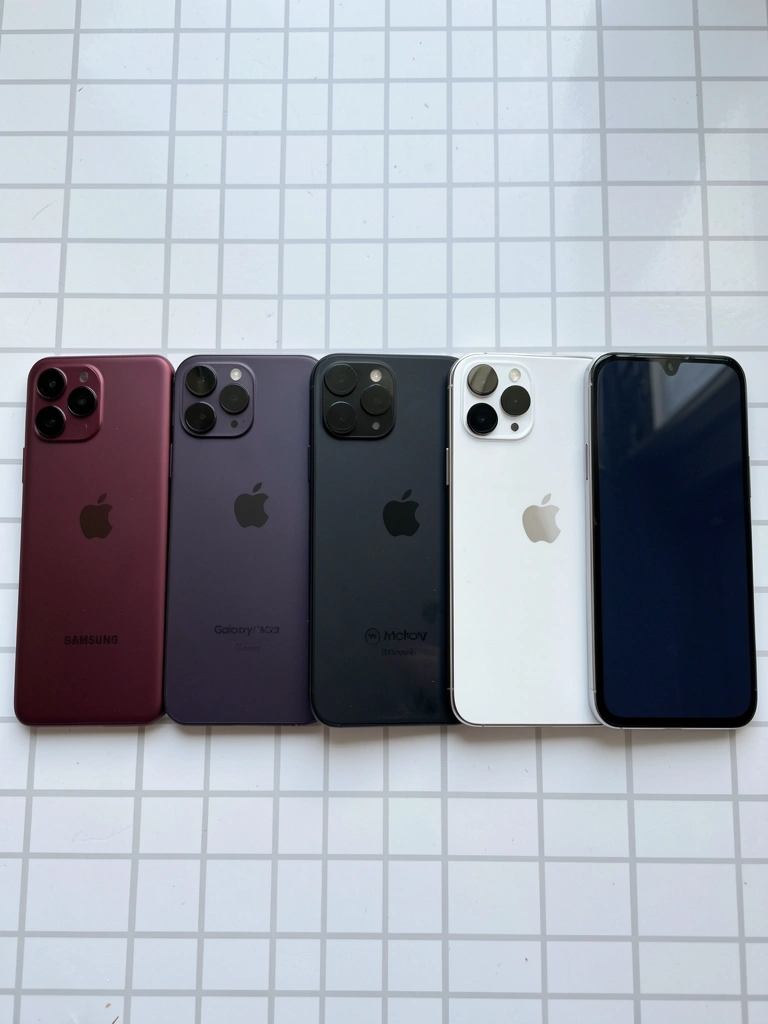 Cinco celulares de diferentes modelos alinhados sobre uma superfície neutra.